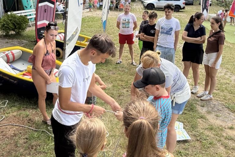 Dzieci biorące udział w grze z zadaniami na pikniku żeglarskim